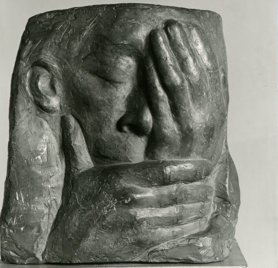 Skulptur einer Figur, die die Hände vor dem Gesicht zusammenschlägt